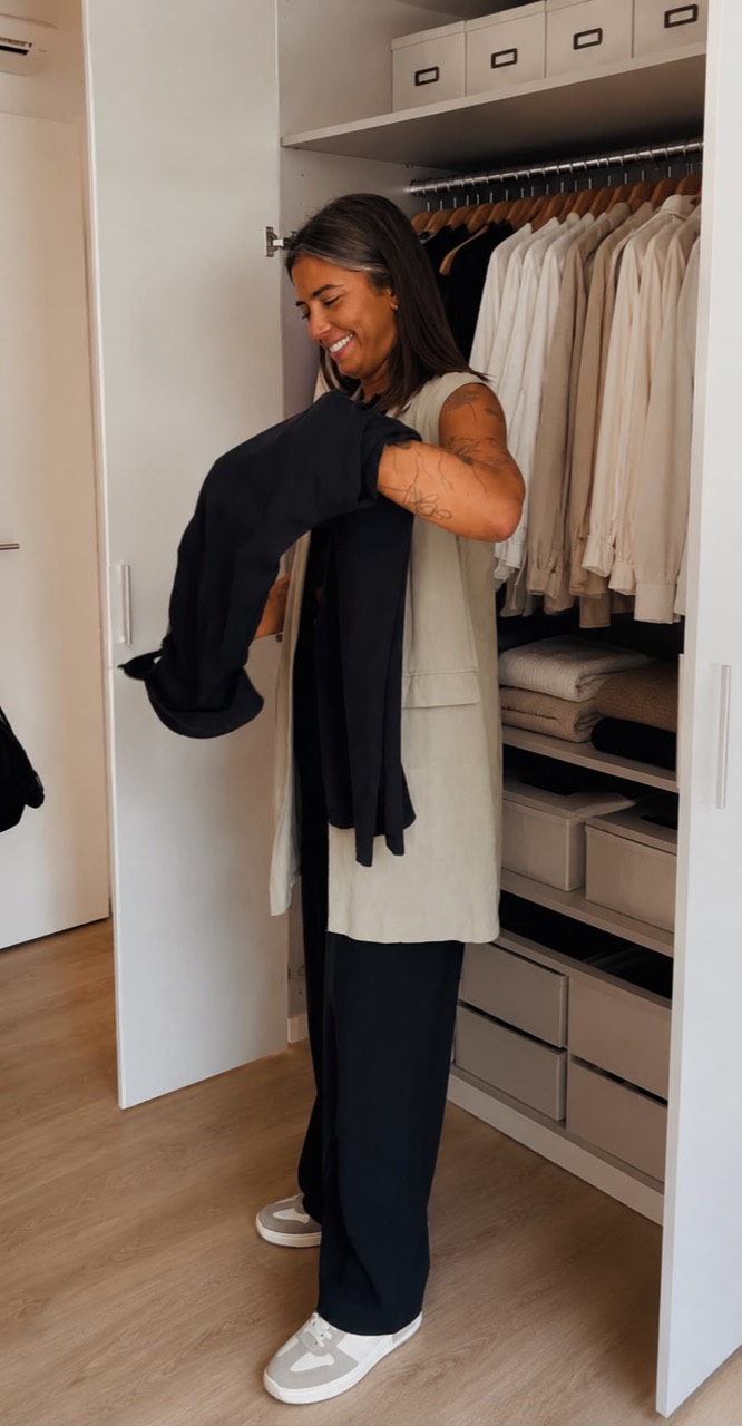 Amanda Gaspar a organizar roupa junto a um roupeiro
